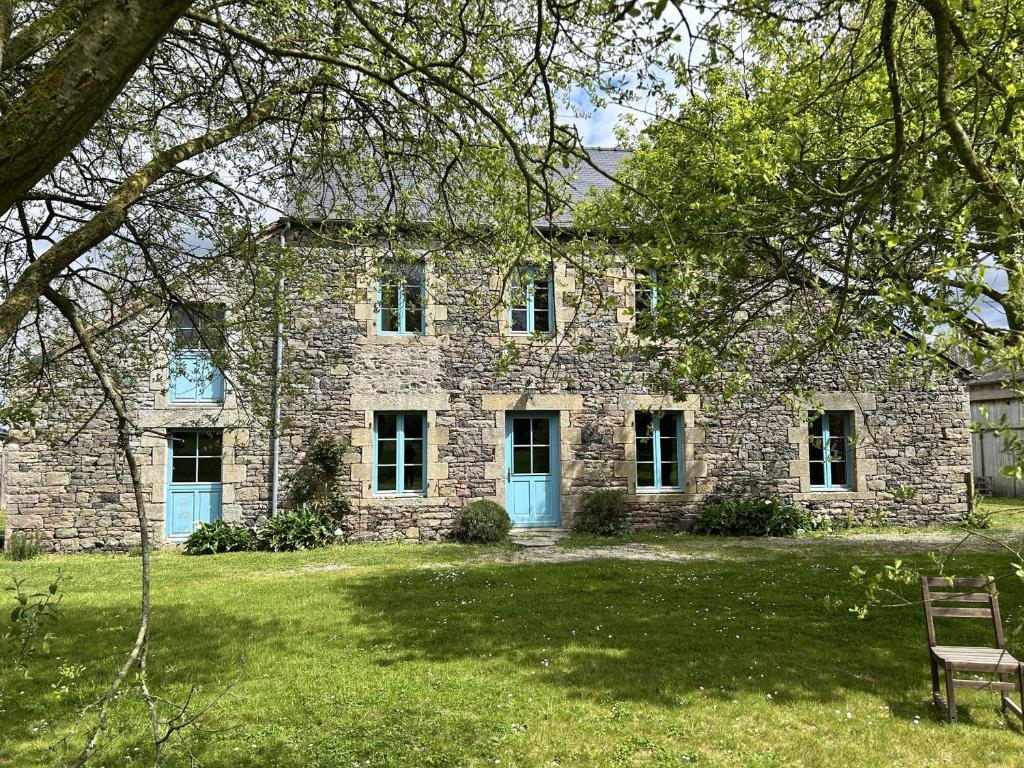 une maison en pierre avec un banc devant elle dans l'établissement 210 - Maison de caractère pour 10 convives, à Plurien