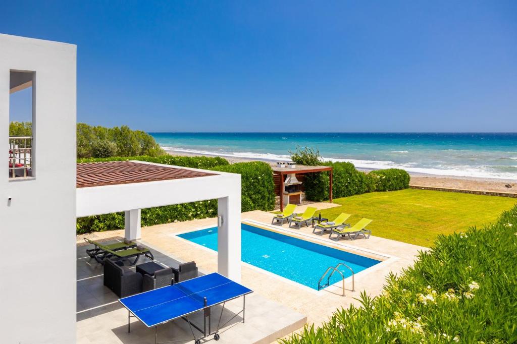 a house with a swimming pool and the ocean at Villa Metis in Lachania