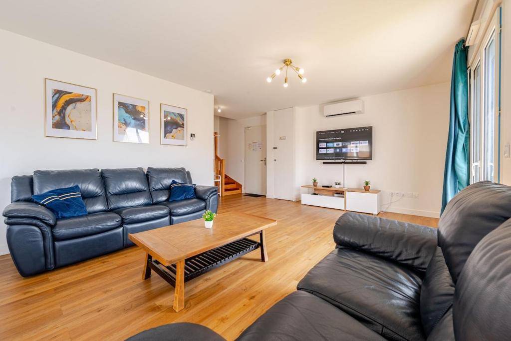 a living room with a couch and a table at Maison Moderne et confortable pour 7 personnes in La Grande-Paroisse