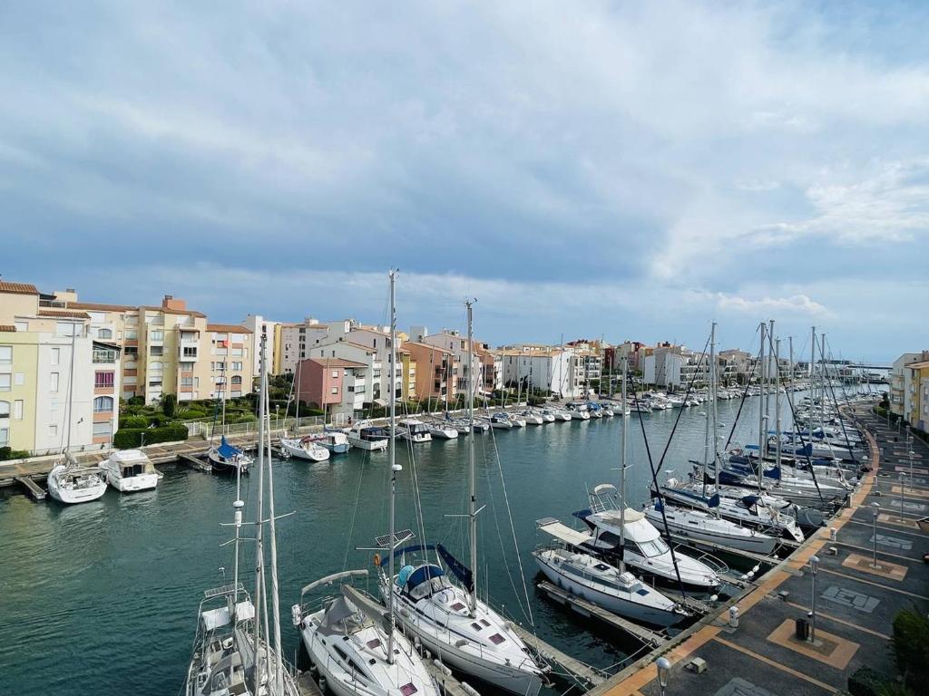 un groupe de bateaux amarrés dans un port avec des bâtiments dans l'établissement Appartement rénové proche plage, clim, parking, wi-fi - FR-1-723-169, au Cap d'Agde