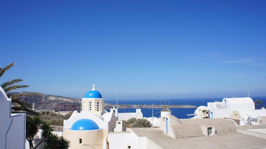 a blue and white building with a blue sky at Marcos Rooms in Oia