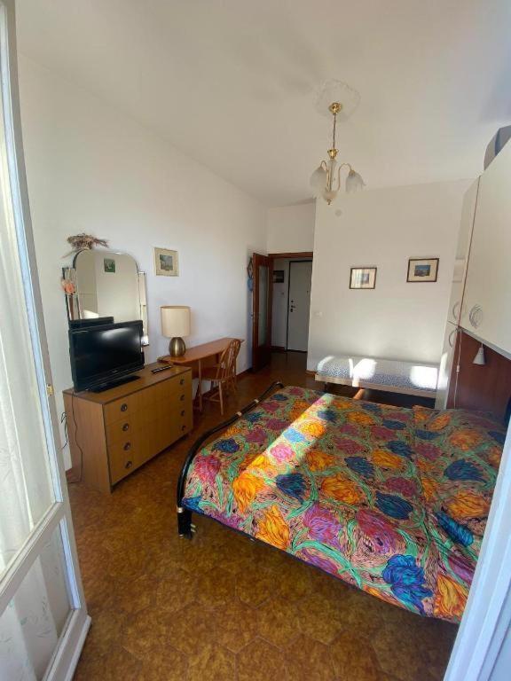 una camera da letto con un letto, una cassettiera e una televisione di PM Via 15 Colombo - Andora a Marina dʼAndora