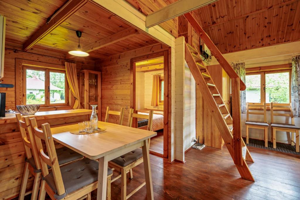 una sala da pranzo con tavolo e una scala in una cabina di Domki Irka nad morzem a Łeba