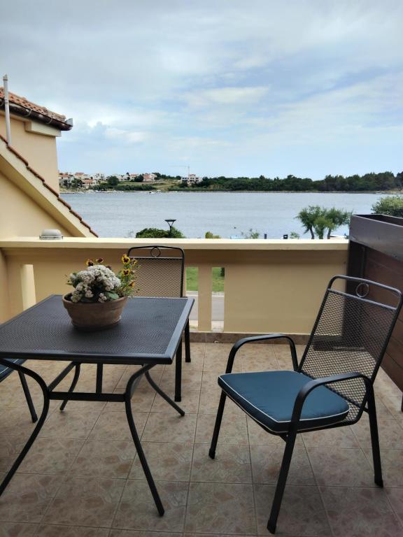 a table and chairs on a balcony with a view of the water at Apartment Tome - room with bathroom and separate kitchen in Nin