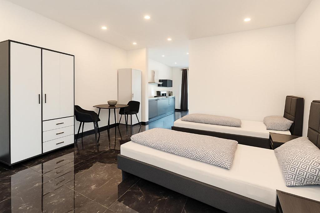 a bedroom with two beds and a kitchen at Werre Apartments mit Smart-TV - stilvol, zentral & wohnlich in Löhne