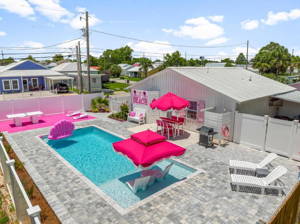 an overhead view of a swimming pool with pink umbrellas at Pink Prerogative Beach Bungalow with Private Pool in Panama City Beach