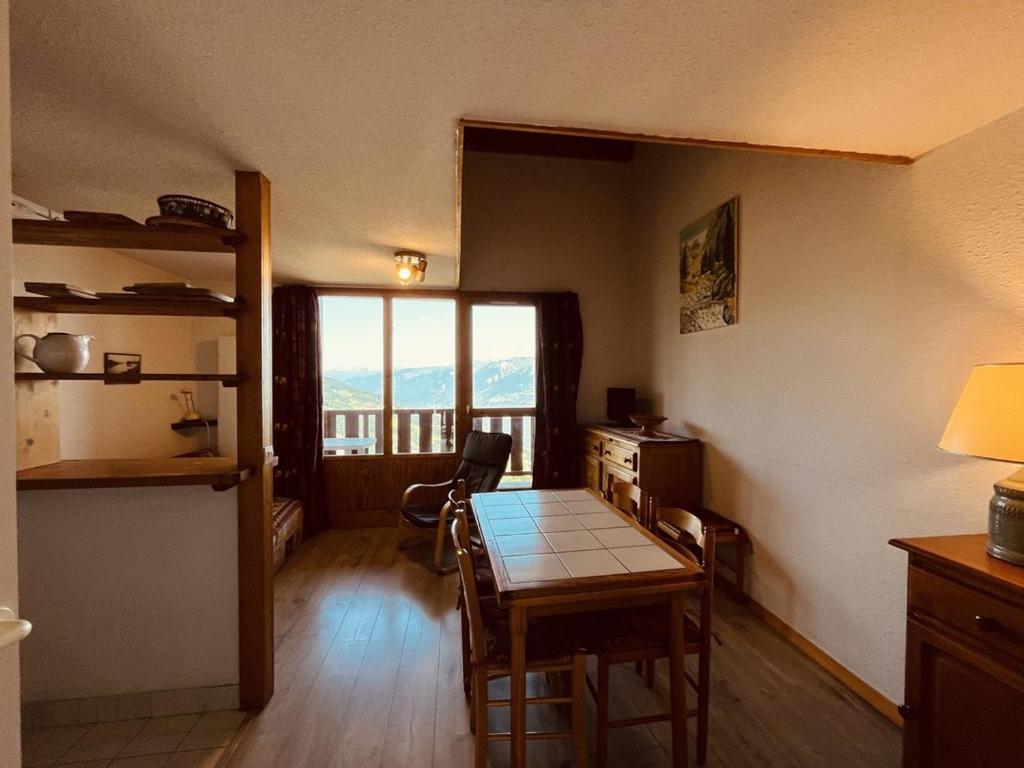 une salle à manger avec une table et une fenêtre dans l'établissement Appartement duplex avec balcon et animaux admis, proche pistes - Vallandry - FR-1-757-103, à Landry