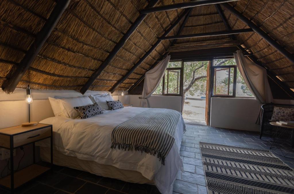 um quarto com uma cama e uma janela grande em Amy's Camp at the Kevin Richardson Foundation em Dinokeng Game Reserve