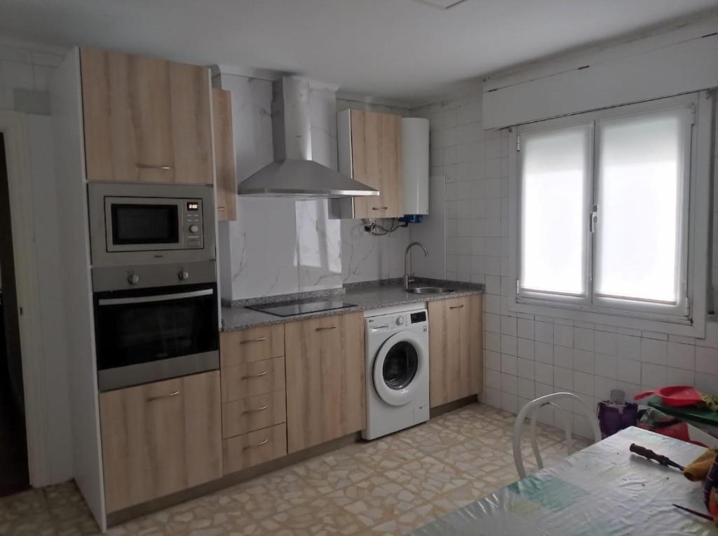 a kitchen with a washing machine and a washer at Habitación individual cerca Bilbao in Sestao