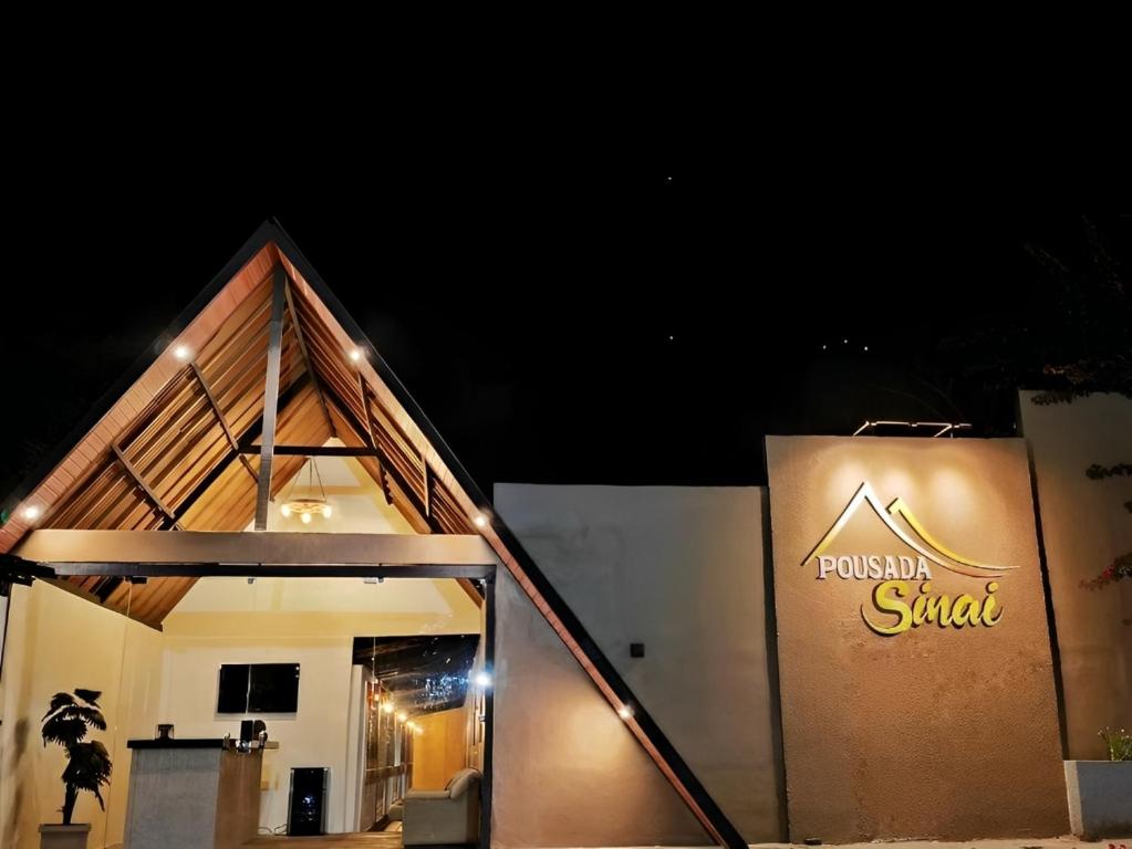 a building with a sign on the side of it at Pousada Sinai in Viçosa