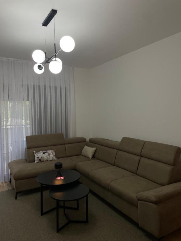 una sala de estar con un sofá y una mesa en Apartman Vida, en Trebinje