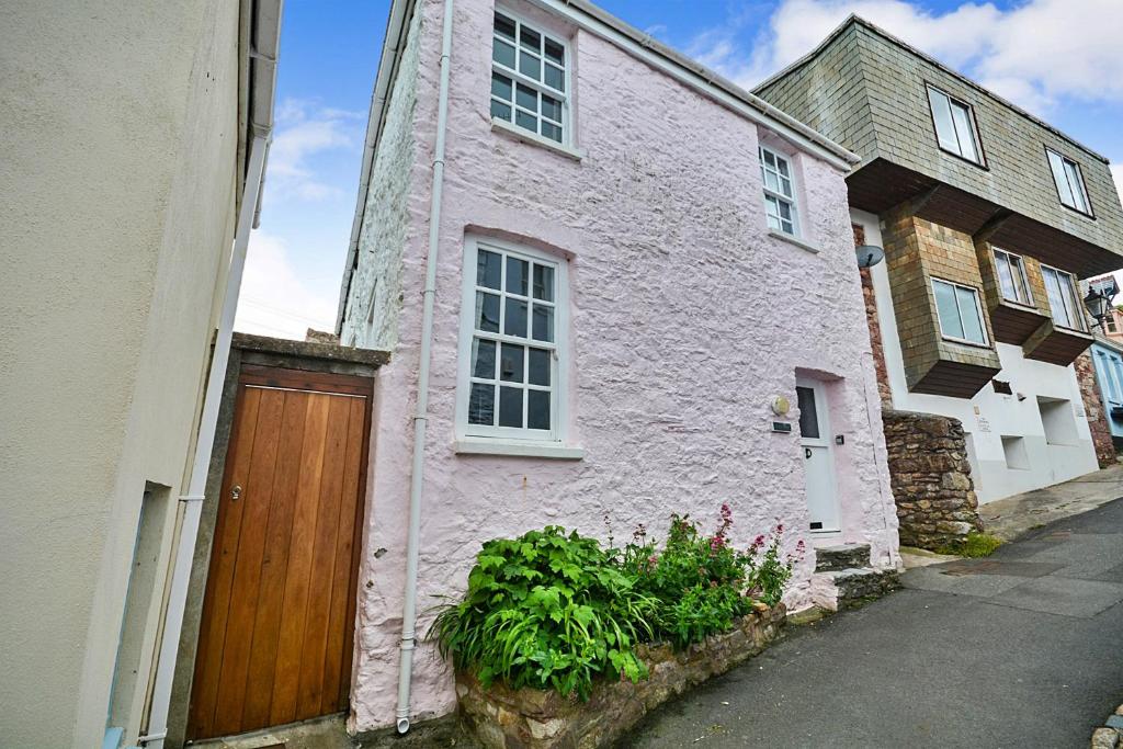 ein weißes Haus mit einer Holztür auf einer Straße in der Unterkunft Finest Retreats - Rose Cottage, Kingsand in Kingsand