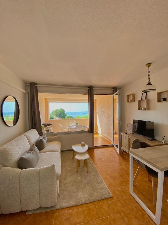 un salon avec un canapé blanc et une table dans l'établissement Lovely studio with sea view, à Sainte-Maxime