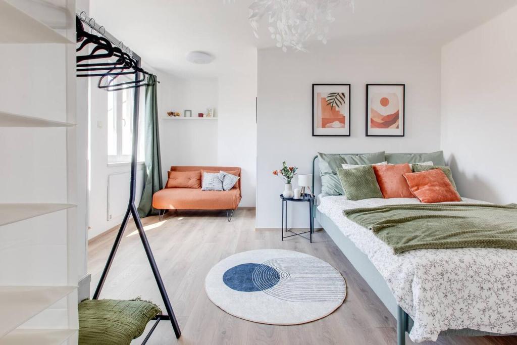 a living room with a bed and a orange chair at Suite Joka Part Dieu Wifi Check in H24 in Fourvière