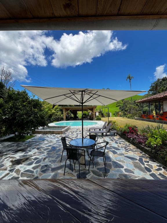 a table and chairs with an umbrella next to a pool at Hotel Hacienda Inglaterra in Sevilla