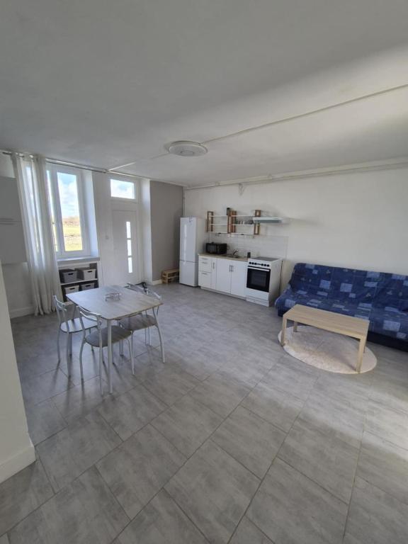 un salon avec un canapé bleu et une table dans l'établissement Maison de village, à Blet