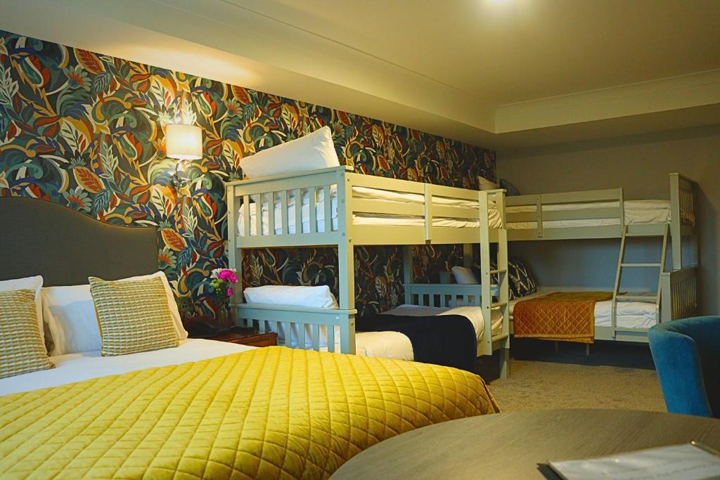 a bedroom with two bunk beds and a yellow bed at The Newgrange Hotel in Navan