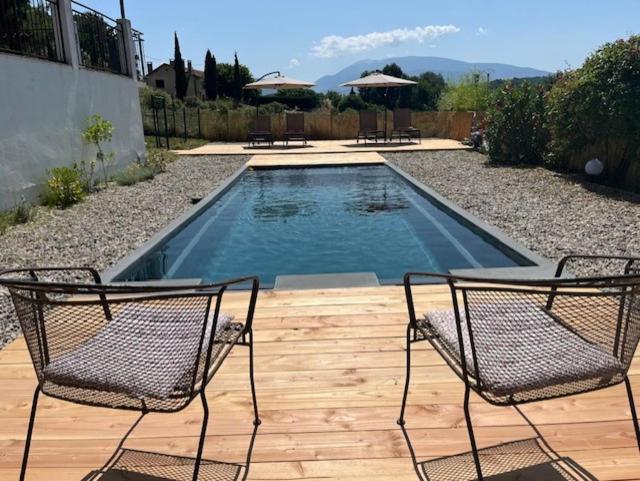 - une piscine avec 2 chaises sur une terrasse en bois dans l'établissement Vacation home with a private pool in Puyméras, à Puyméras