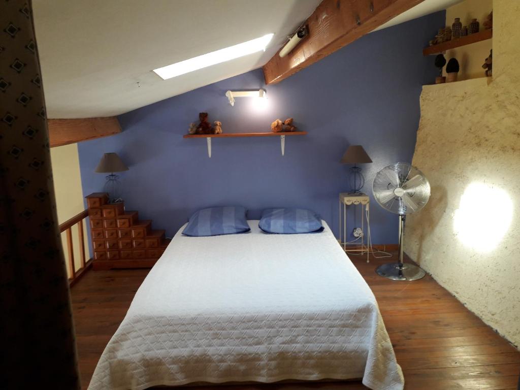 - une chambre avec un lit blanc et un mur bleu dans l'établissement Appartement , rue piétonne , centre village, à Nissan-lez-Enserune