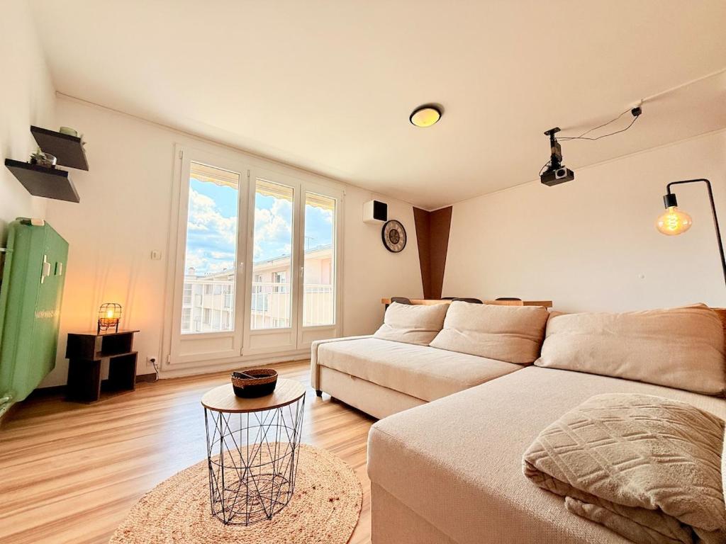 un salon avec un canapé et une grande fenêtre dans l'établissement Le Trey, à Besançon