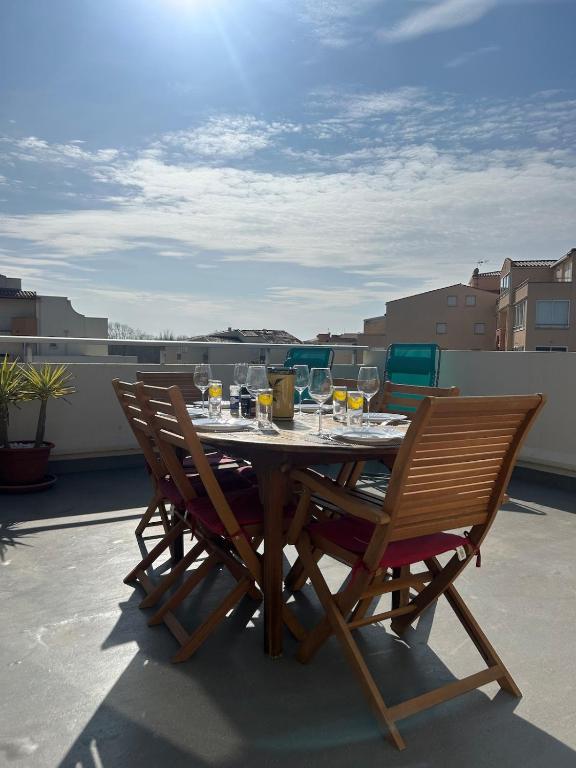 - une table et des chaises sur un balcon avec des verres à vin dans l'établissement La Maison du Bonheur, au Cap d'Agde
