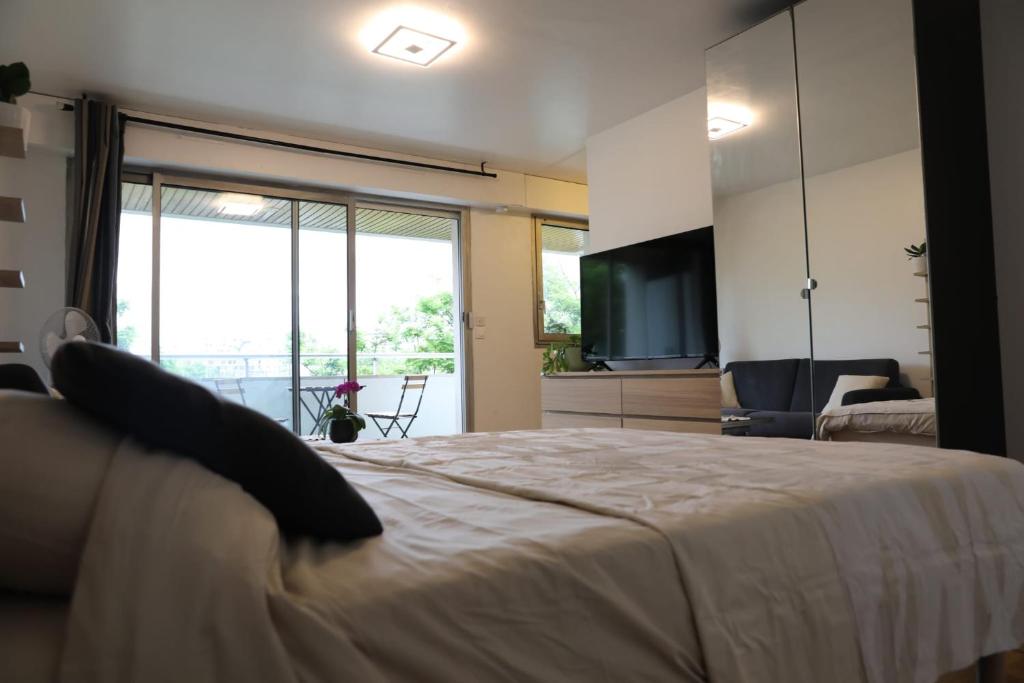 une chambre avec un grand lit avec une télévision et un salon dans l'établissement Magnifique studio emplacement premium, à Paris
