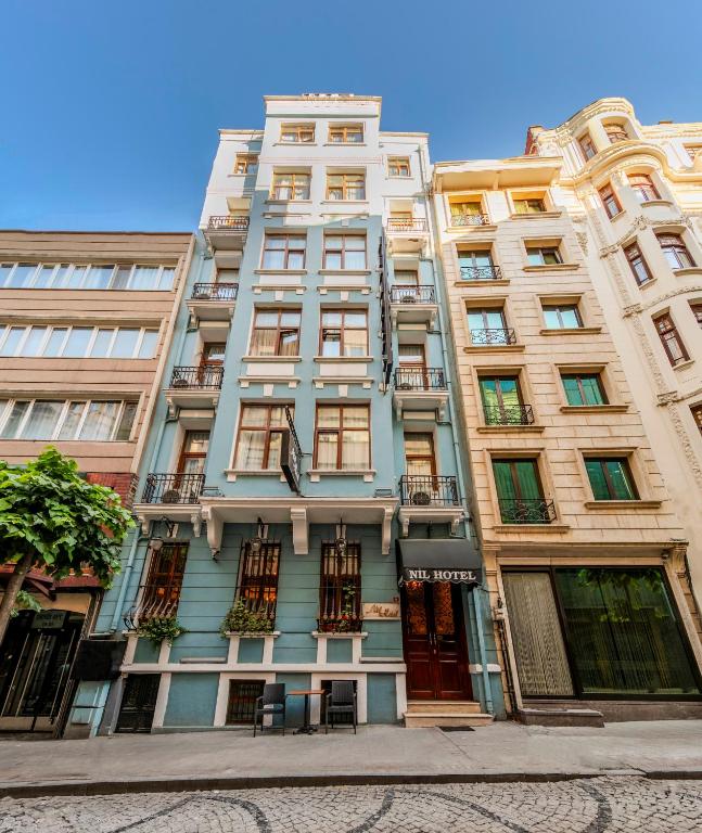 a tall building with many windows on a street at Nil Hotel İstanbul City Center in Istanbul