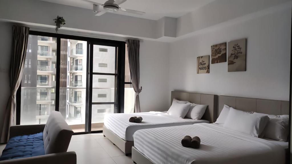two beds in a room with a large window at Joyful Stay at Midhills Genting in Genting Highlands