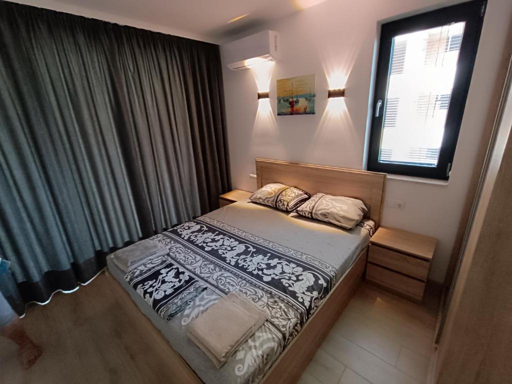 a bedroom with a bed and a window at Апартамент 10 улица Македония 33 in Pomorie
