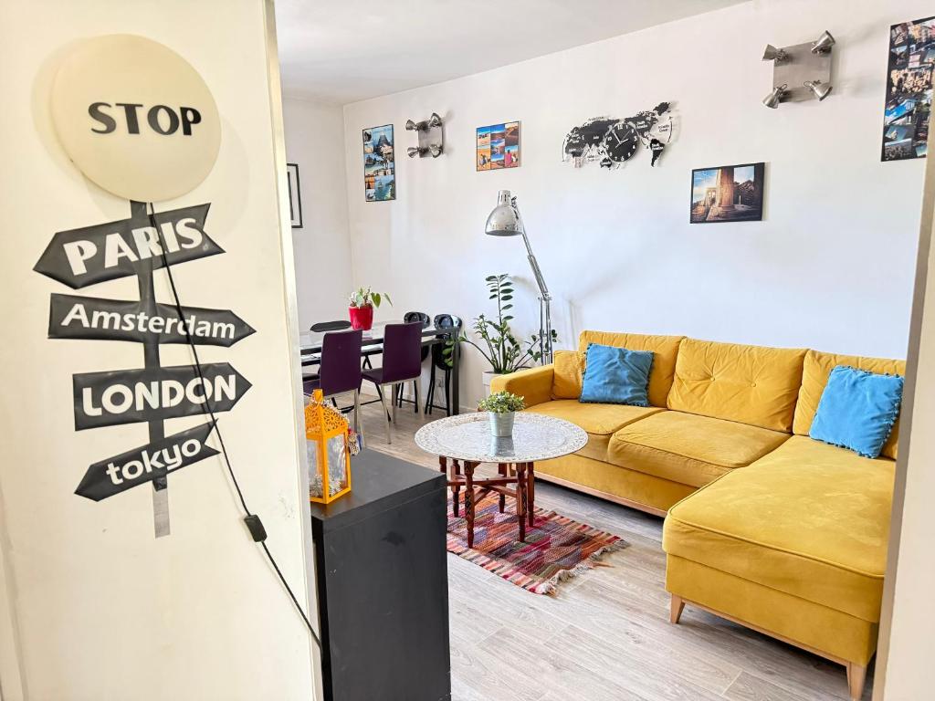 un salon avec un canapé jaune et une table dans l'établissement Sweet Home-PARKING GRATUIT - Appartement-proche centre ville-2 chambres, à Aix-en-Provence