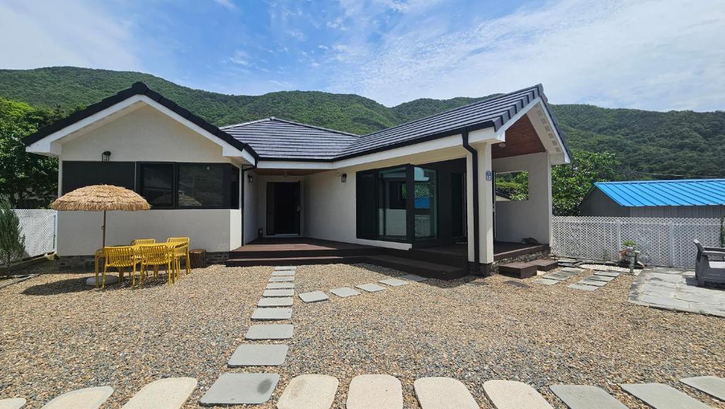 a small white house with a table and chairs at Yeon Stay Miryang in Miryang