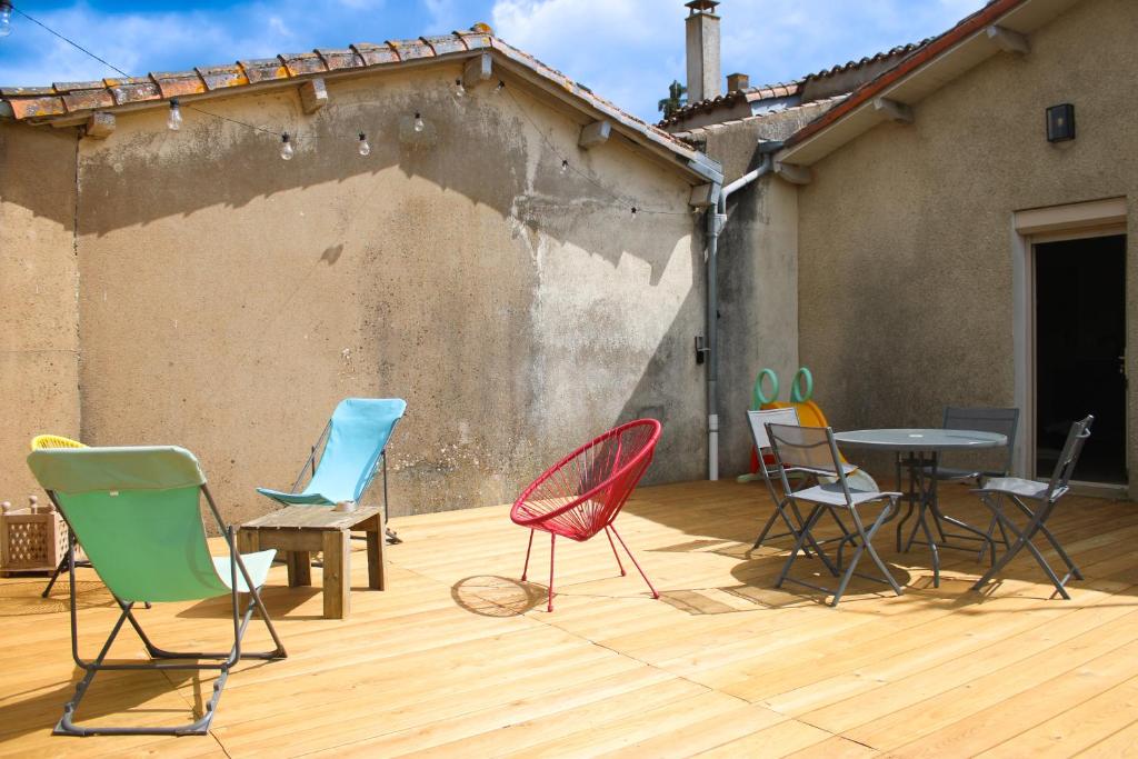 un groupe de chaises et de tables sur une terrasse dans l'établissement Gîte le Puy Pin, 4 personnes, à Sevremont