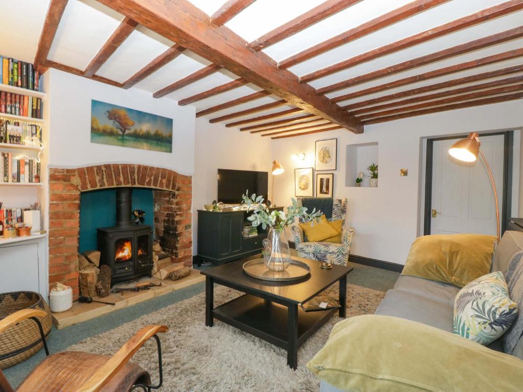 a living room with a couch and a fireplace at Elm Cottage in Moreton in Marsh