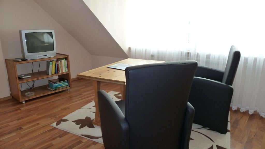 ヘルゴラントにあるHaus Elisaのテーブル、椅子2脚、テレビが備わる客室です。