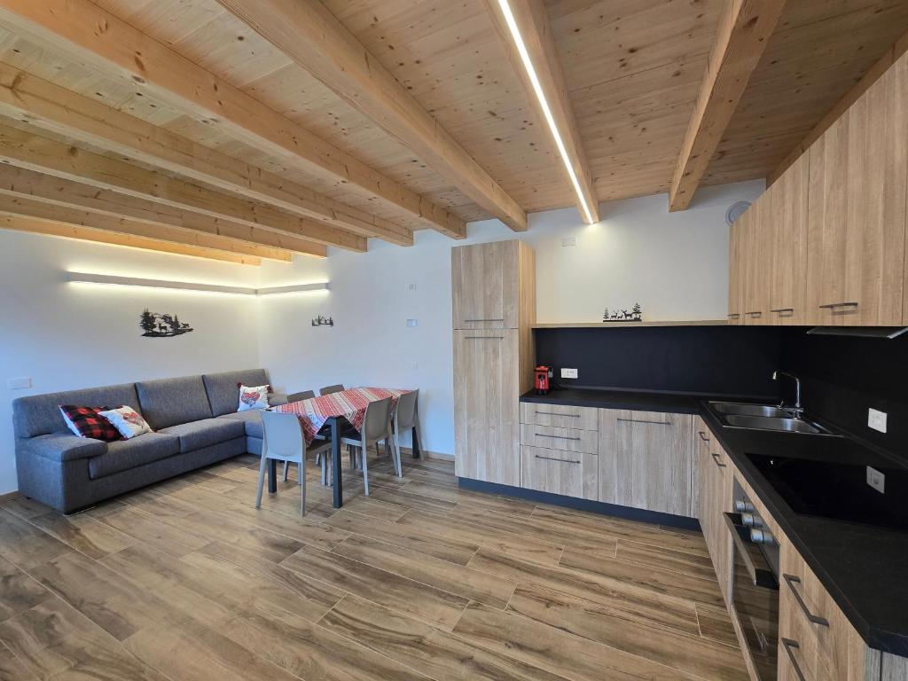 a kitchen and living room with a couch and a table at Miravalli Home in Gosaldo
