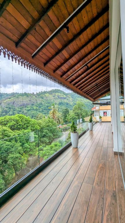 a large wooden deck with a view of the mountains at Royal Lion Hotel - Kandy Road, Galagadara in Galagedara