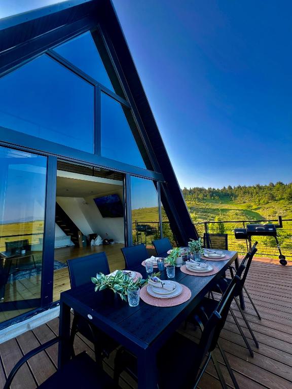 a table on the deck of a house with a view at TriPeak in Bjelašnica