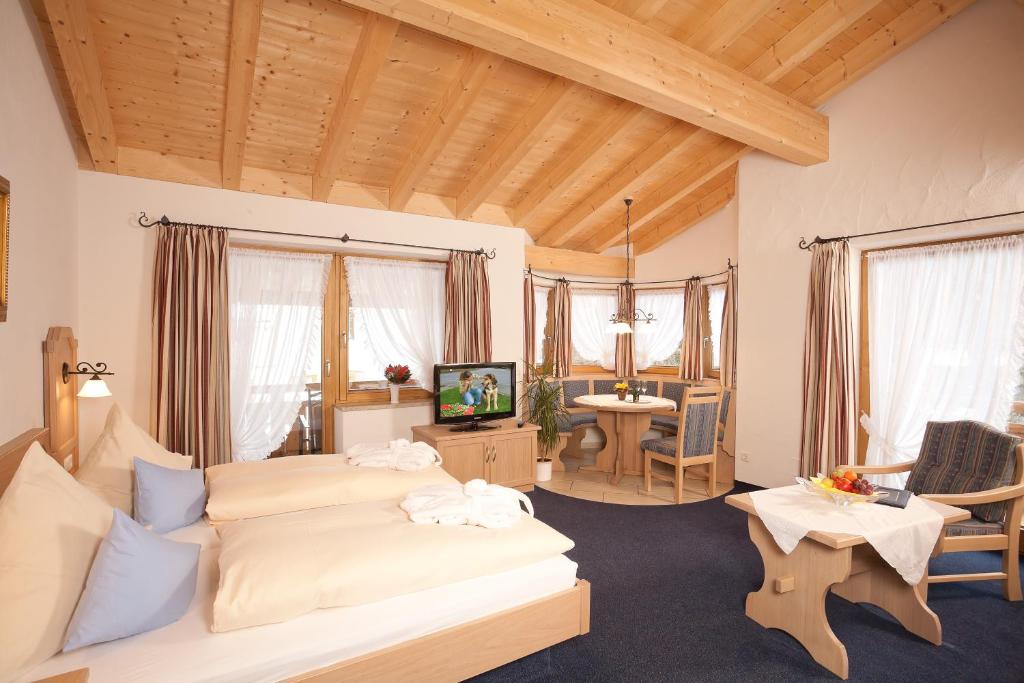 ein Schlafzimmer mit einem Bett und ein Wohnzimmer in der Unterkunft Hotel Landhaus Feldmeier ***S in Oberammergau