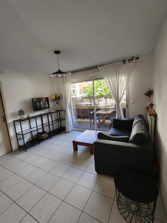 un salon avec un canapé et une table dans l'établissement appartement terrasse Montpellier, à Montpellier