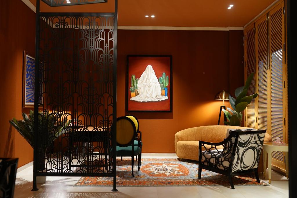 a living room with a door with a chair and a couch at The LC Hotel in Lahore