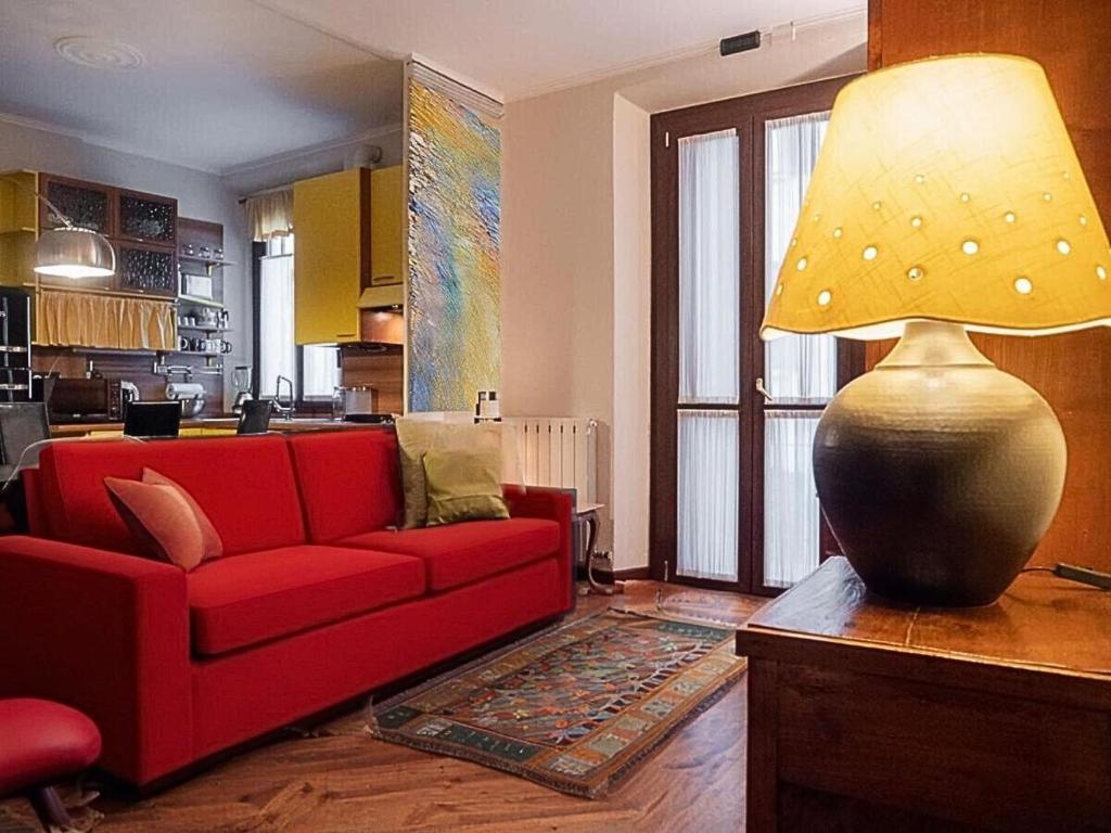 salon z czerwoną kanapą i lampą w obiekcie VFH Stylish Boutique Apartment-City Center w Mediolanie