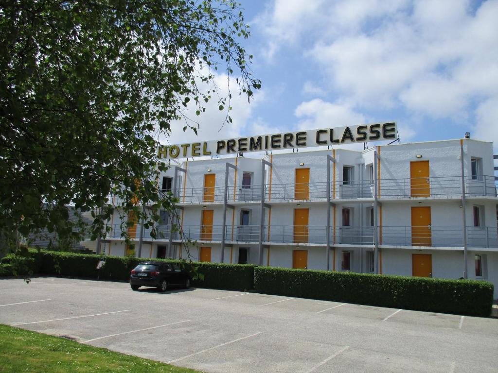 a building with a car parked in front of it at Première Classe Cherbourg - Tourlaville in Cherbourg en Cotentin