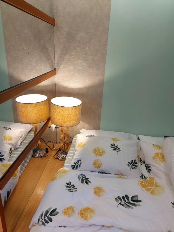 a bedroom with two bunk beds and two lamps at Great Location, Swimming pool, Shops, Staycation in Iloilo City