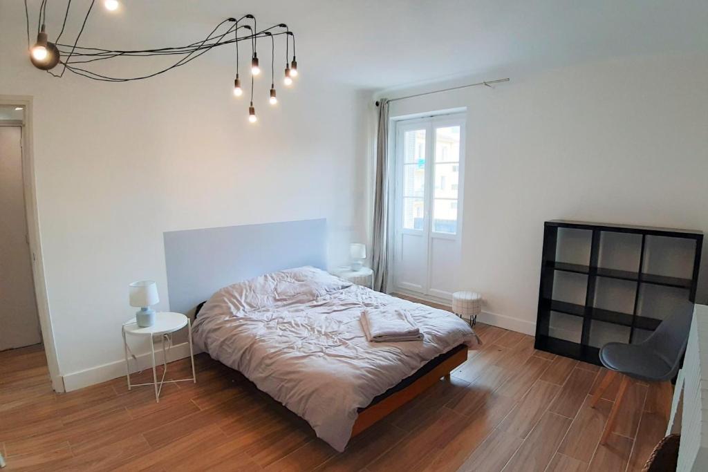 une chambre avec un lit, une table et un lustre dans l'établissement Nunzia - City center Spacious Near train station, à Ajaccio