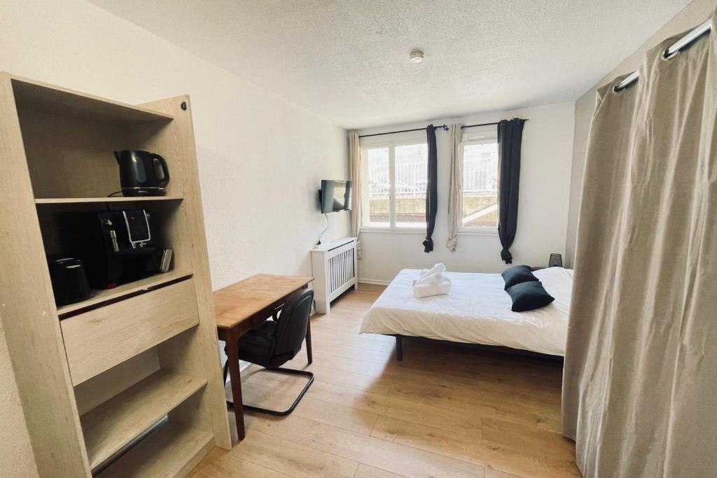 une petite chambre avec un lit et un bureau dans l'établissement Studio of 21m 2 near the heart of Toulouse, à Toulouse