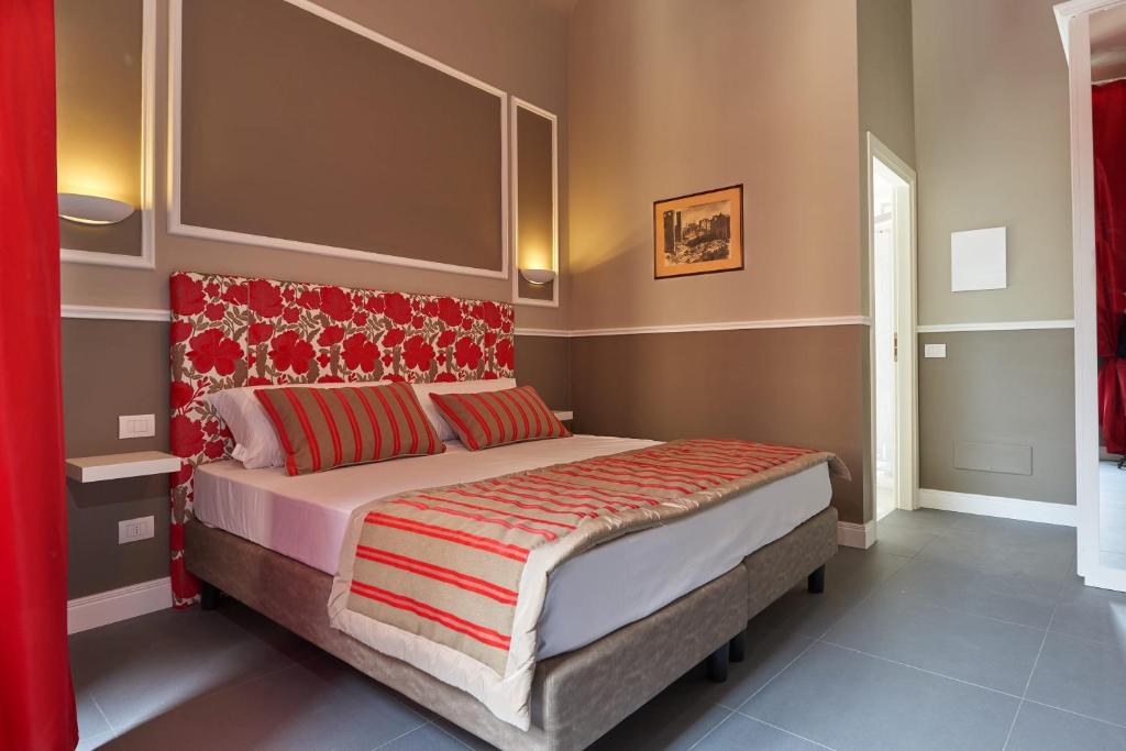 a bedroom with a bed with a red headboard at My Guest in Florence in Florence