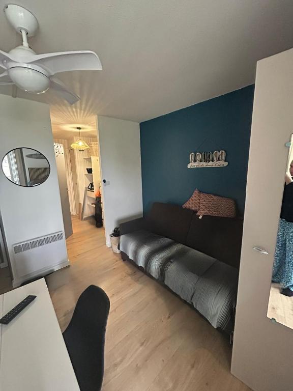 un salon avec un canapé et un mur bleu dans l'établissement Appartement 4 personnes secteur falaise avec parking, au Cap d'Agde