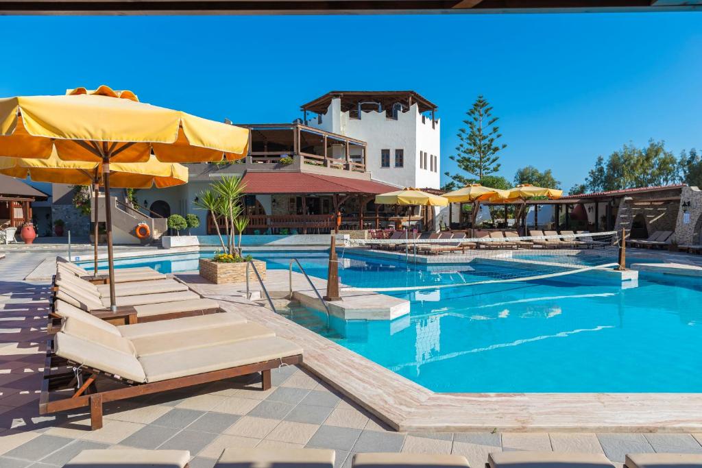 ein großer Pool mit Stühlen und Sonnenschirmen in der Unterkunft Gaia Garden in Kos-Stadt