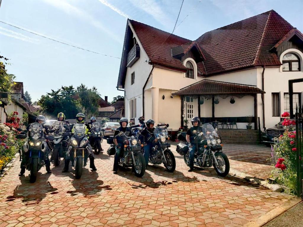 a group of people on motorcycles parked in front of a house at Pensiunea Millenium Sibiu with Parking - motorcycle friendly travel routes in Sibiu