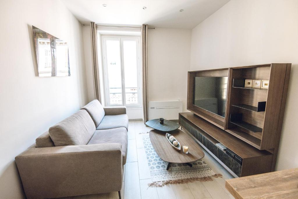 un salon avec un canapé et une télévision dans l'établissement Hyper Centre de Nice - Agréable 3 pièces, à Nice